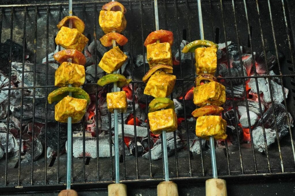 BBQ Grilled Paneer Tikka add skewers on charcoal basket
