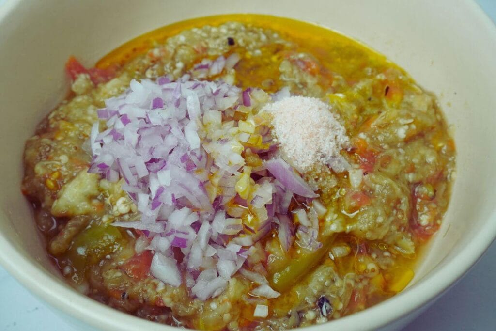 BBQ mashed eggplant mixing chopped onion and mustard oil