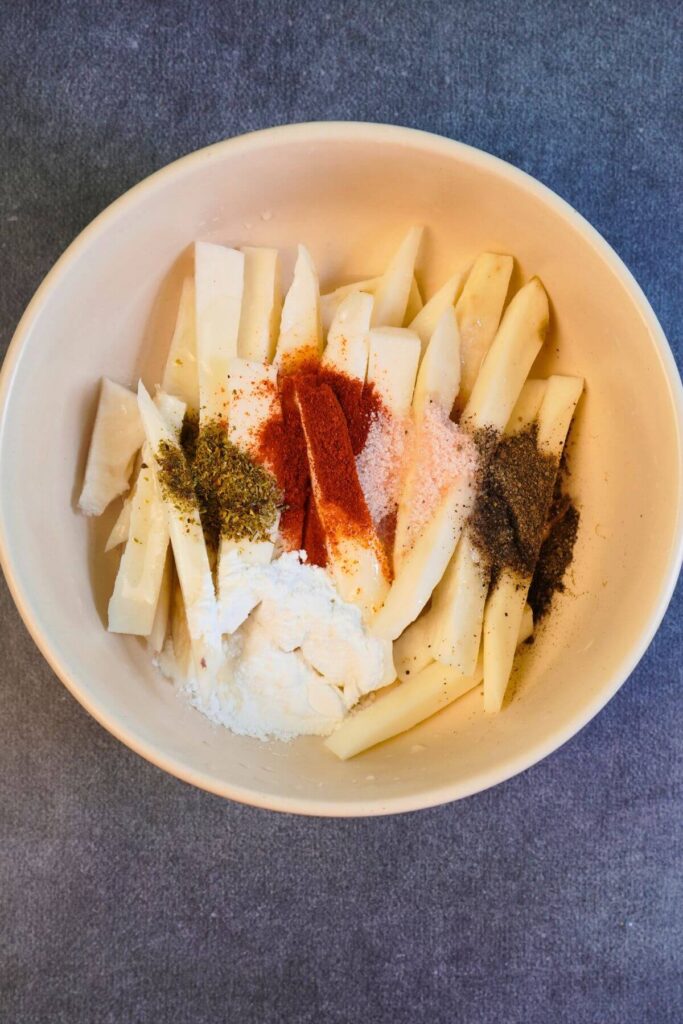 air fryer sweet potato french fries added spices in mixing bowl
